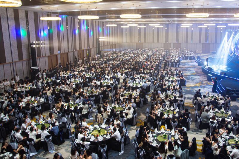 500-pax corporate awards gala in Da Nang with banquet seating, stage lighting, and LED screen during trophy presentation